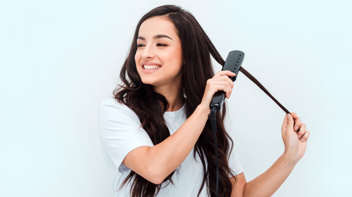 A woman straightening her hair.