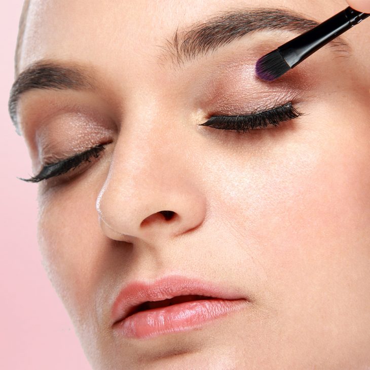 A woman applying base colour (eyeshadow) 