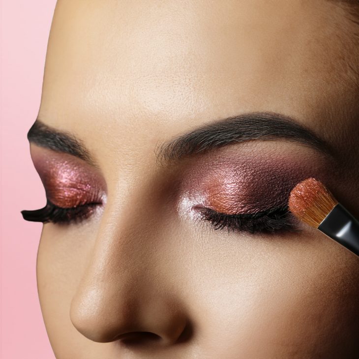 A woman applying eyeshadow on outer corner 