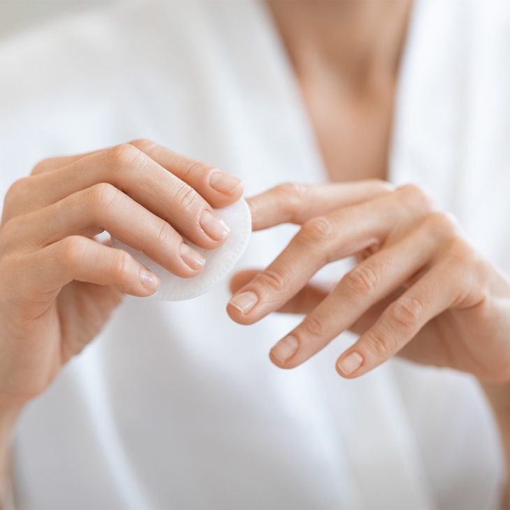 Woman using acetone-free nail polish remover 