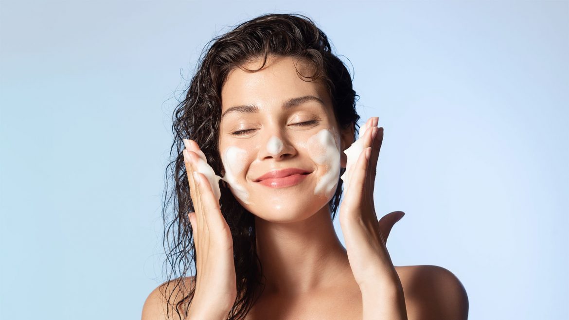 A woman cleansing her facw