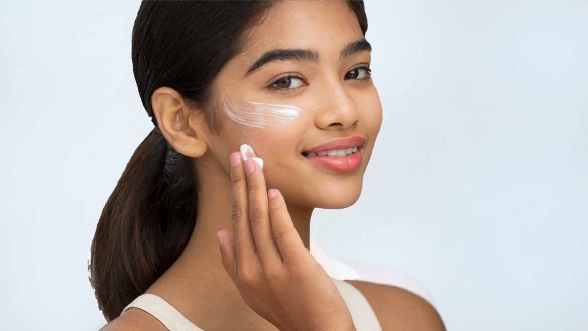 A woman applying face primer to her face 