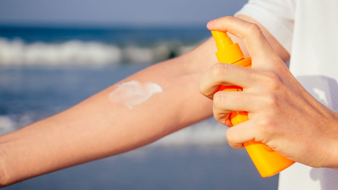 A man applying sunscreen on his hand