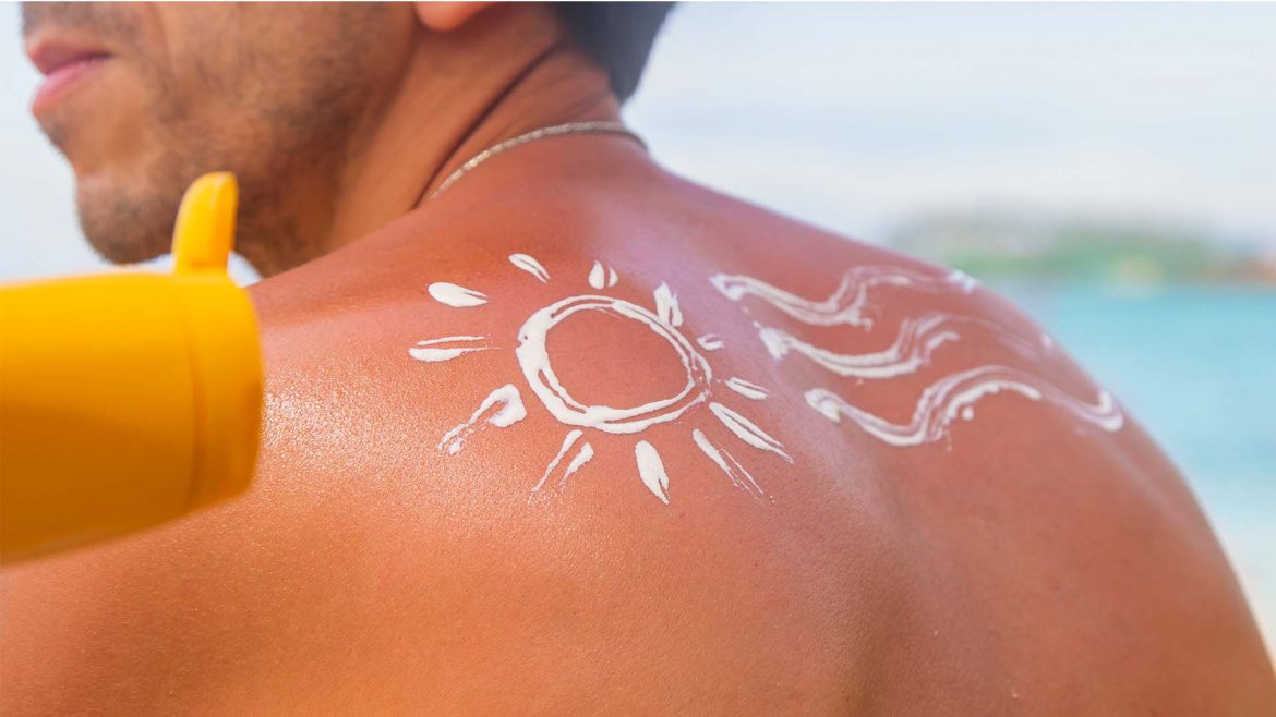 A man applying sunscreen on his back