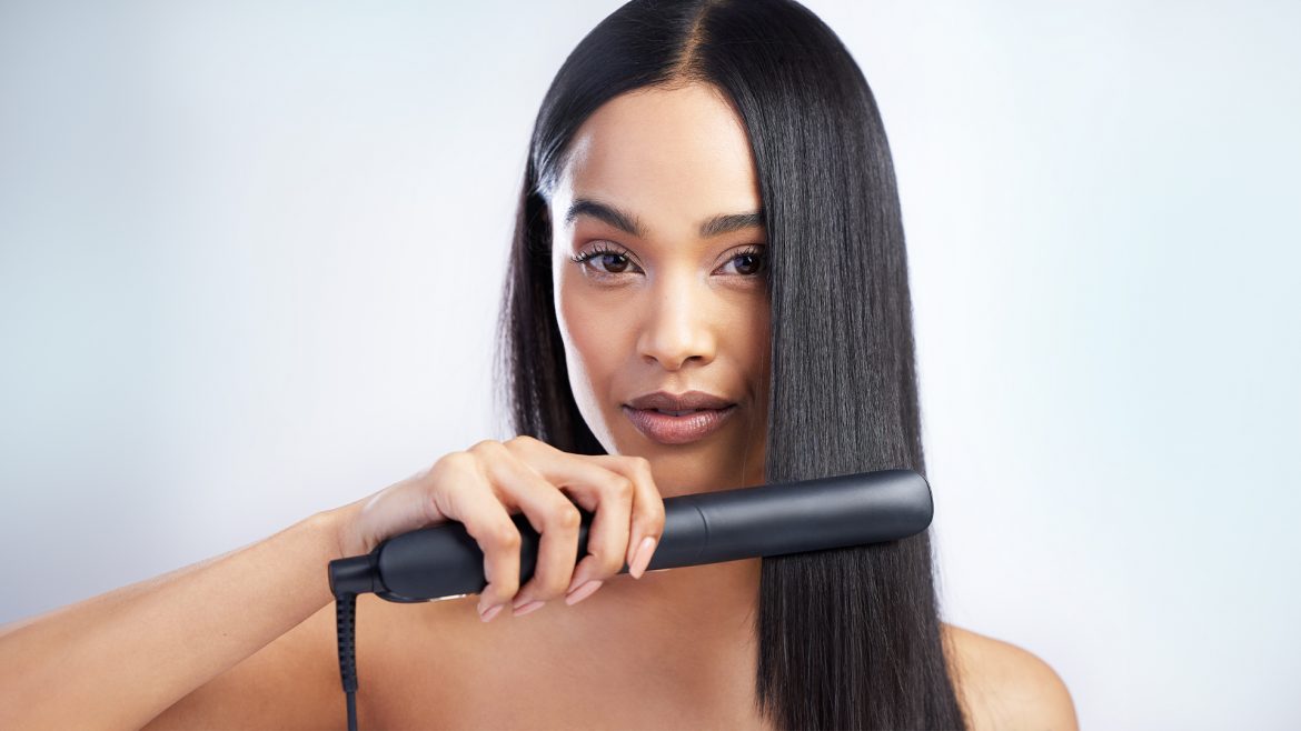 A woman straightening her hair.