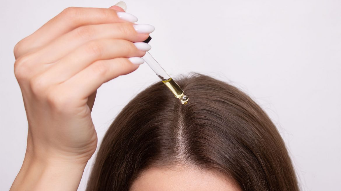 Woman applying hair oil to her hair