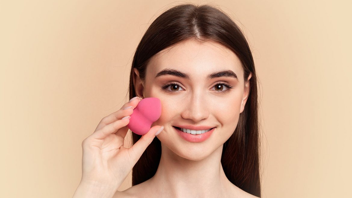 Woman with a foundation sponge in her hand