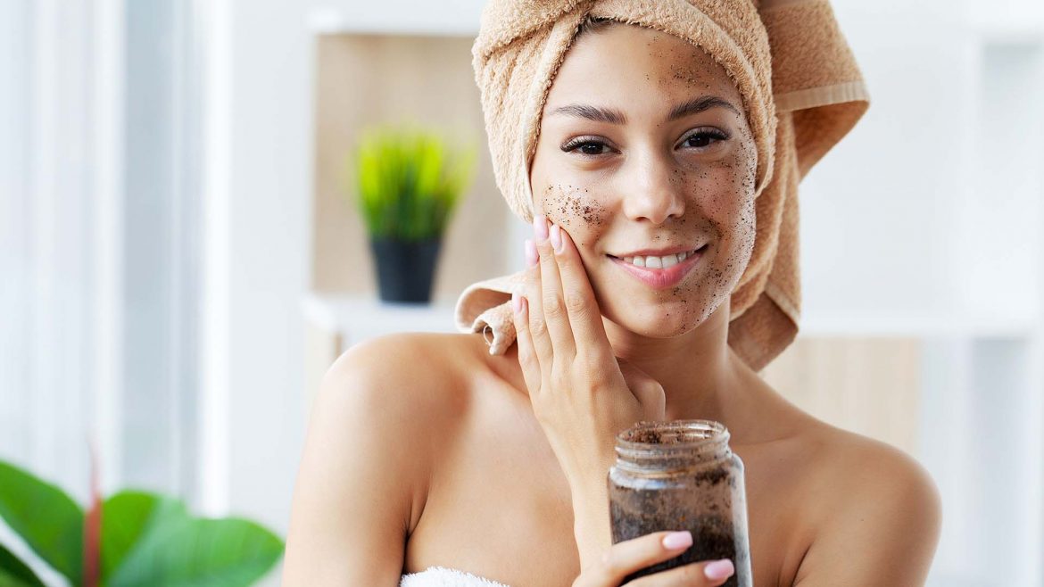 Woman applying coffee mask on her skin