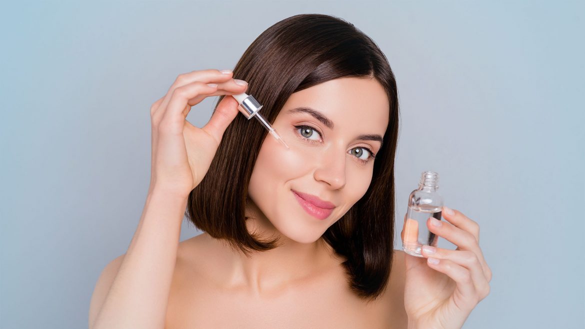 Woman applying serum on her face