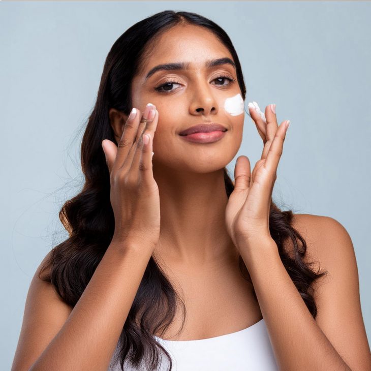 Woman applying moisturising on her face