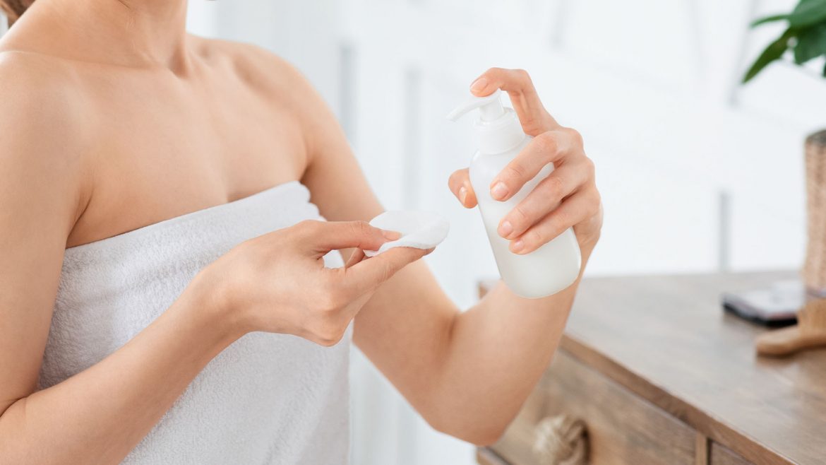 Woman applying face toner 