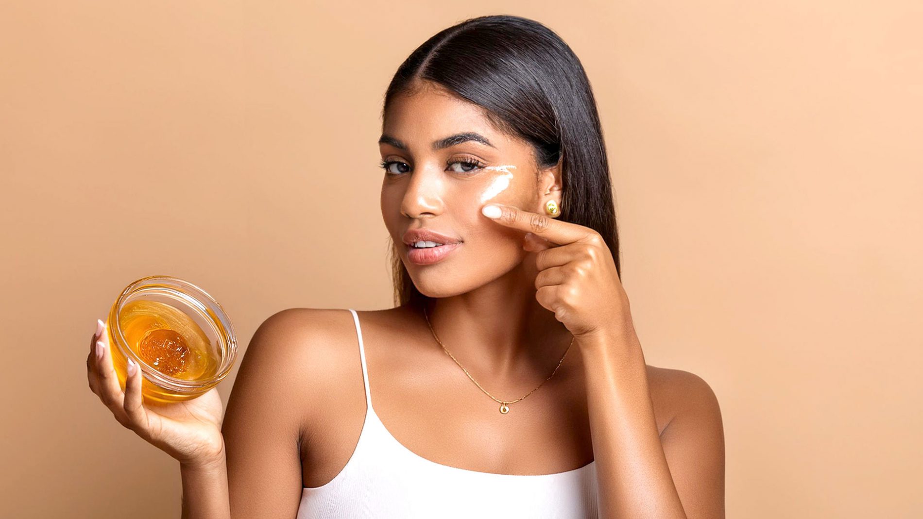 Woman applying honey on her face