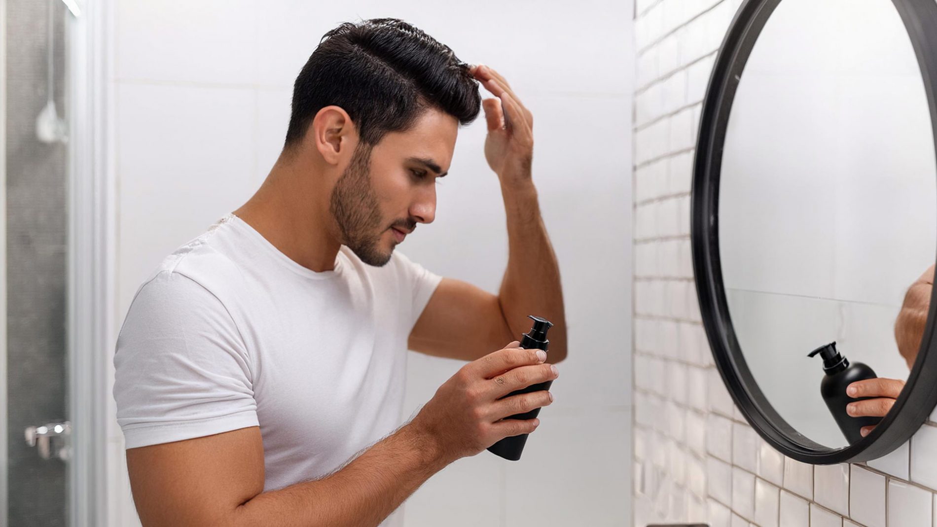 Man applying hair styling product to his hair