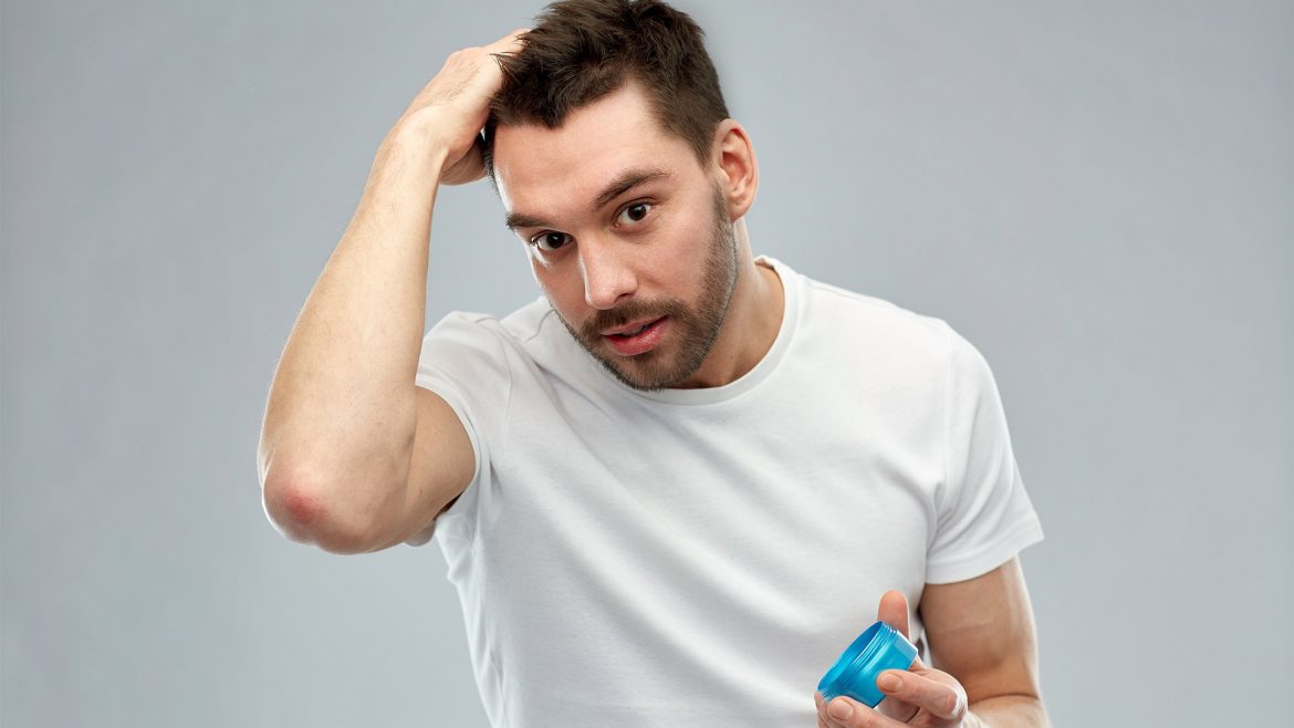 Man applying hair gel to his hair