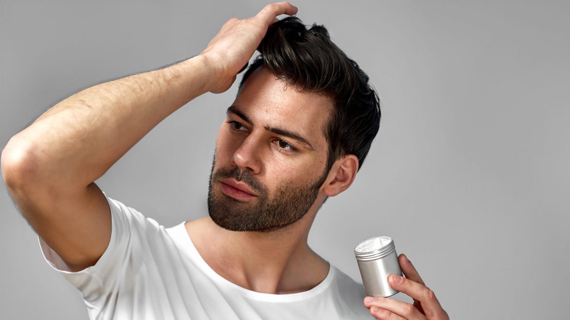 Man applying hair wax to his hair