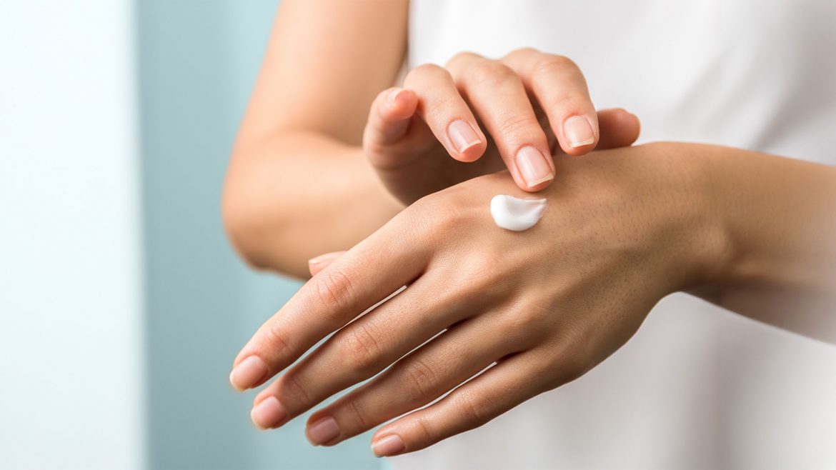 Woman applying body lotion to her hand